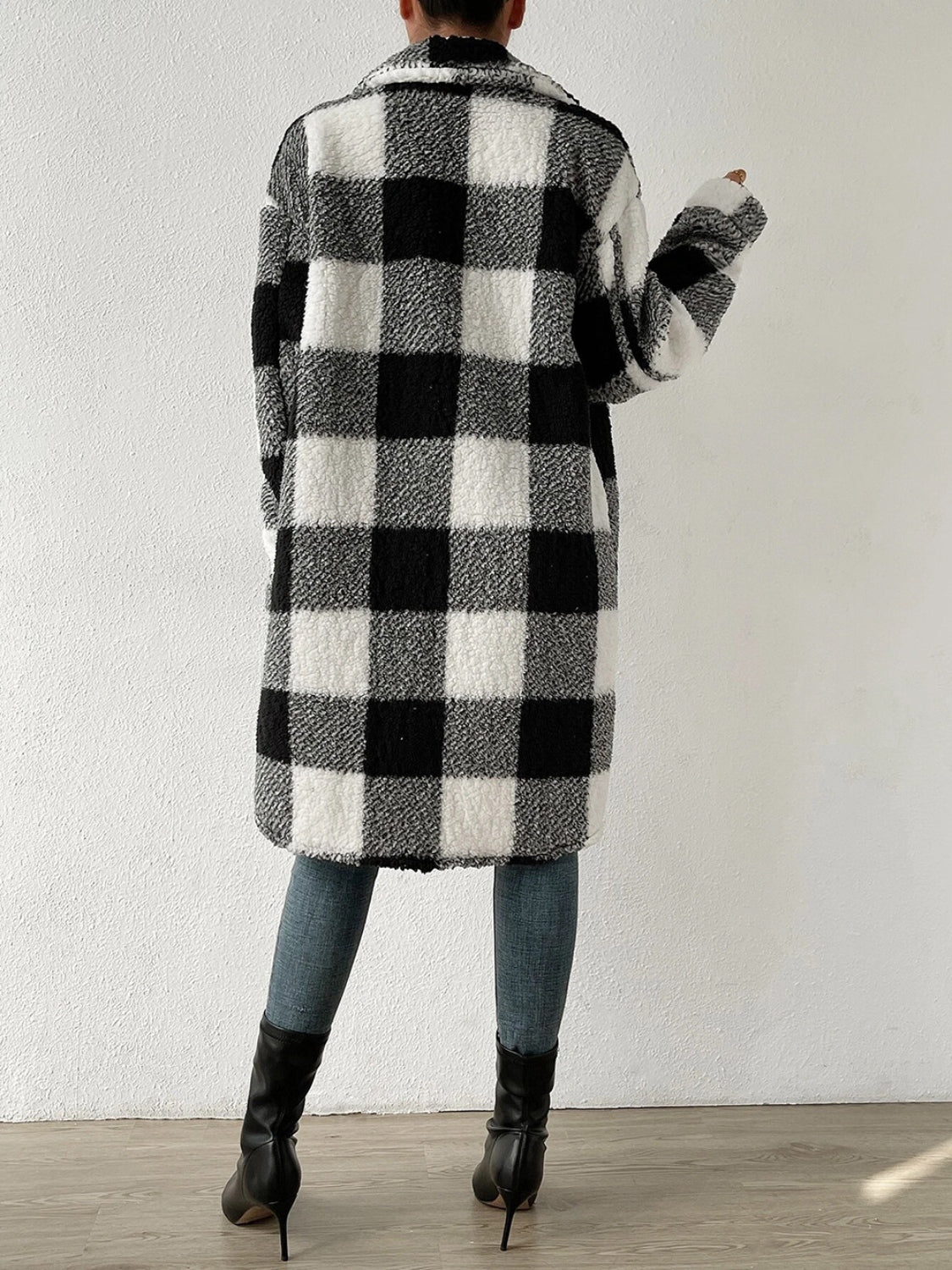 Plaid collared neck button down coat with black and white check pattern.