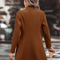 Woman wearing a collared neck button up long sleeve coat in brown.