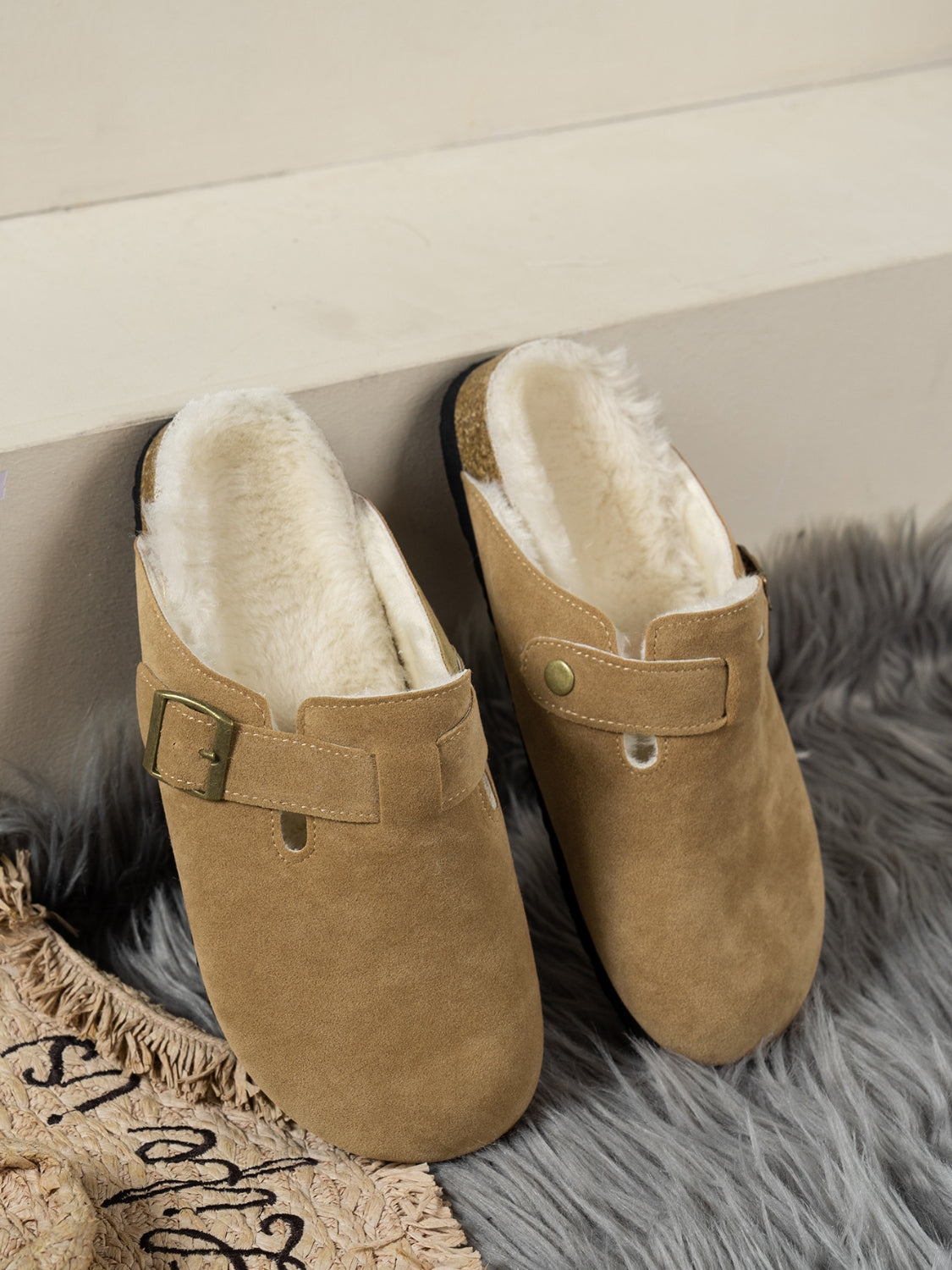 Suede round toe slippers with faux fur lining and flat heel.