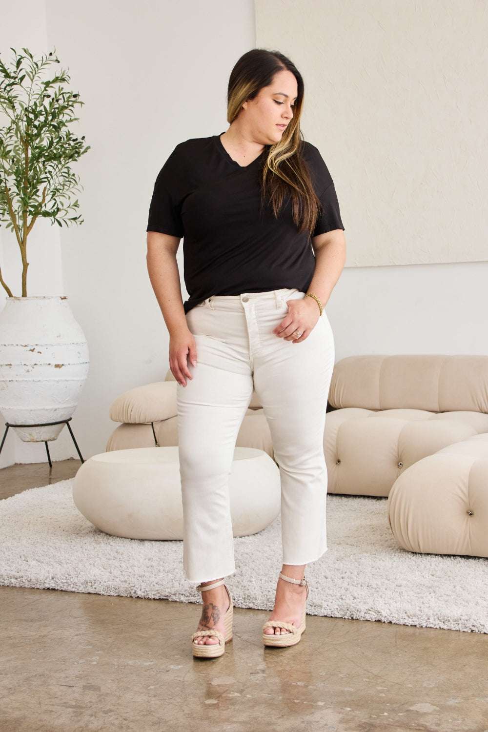 RFM Mini Mia high waist raw hem jeans, tummy control, model in neutral setting.