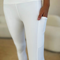 Wide waistband sports leggings in white, featuring stretchy and opaque fabric with side pocket.