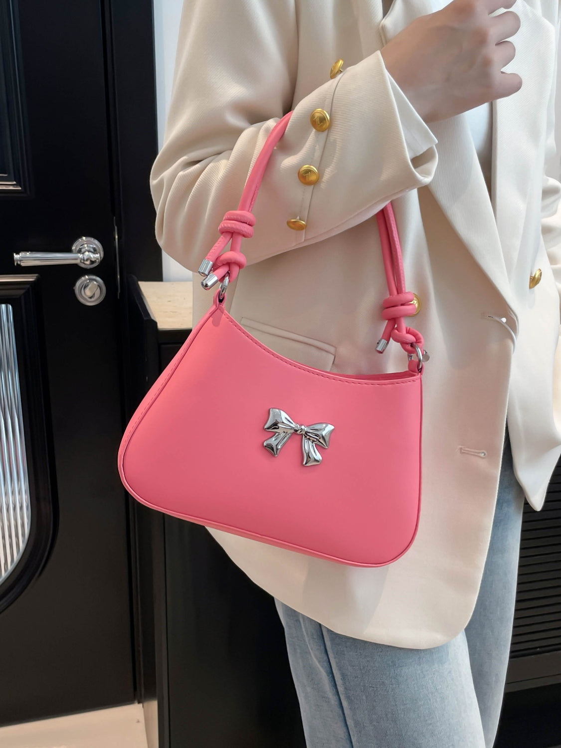 Small pink PU leather handbag with a knotted strap and decorative bow design.