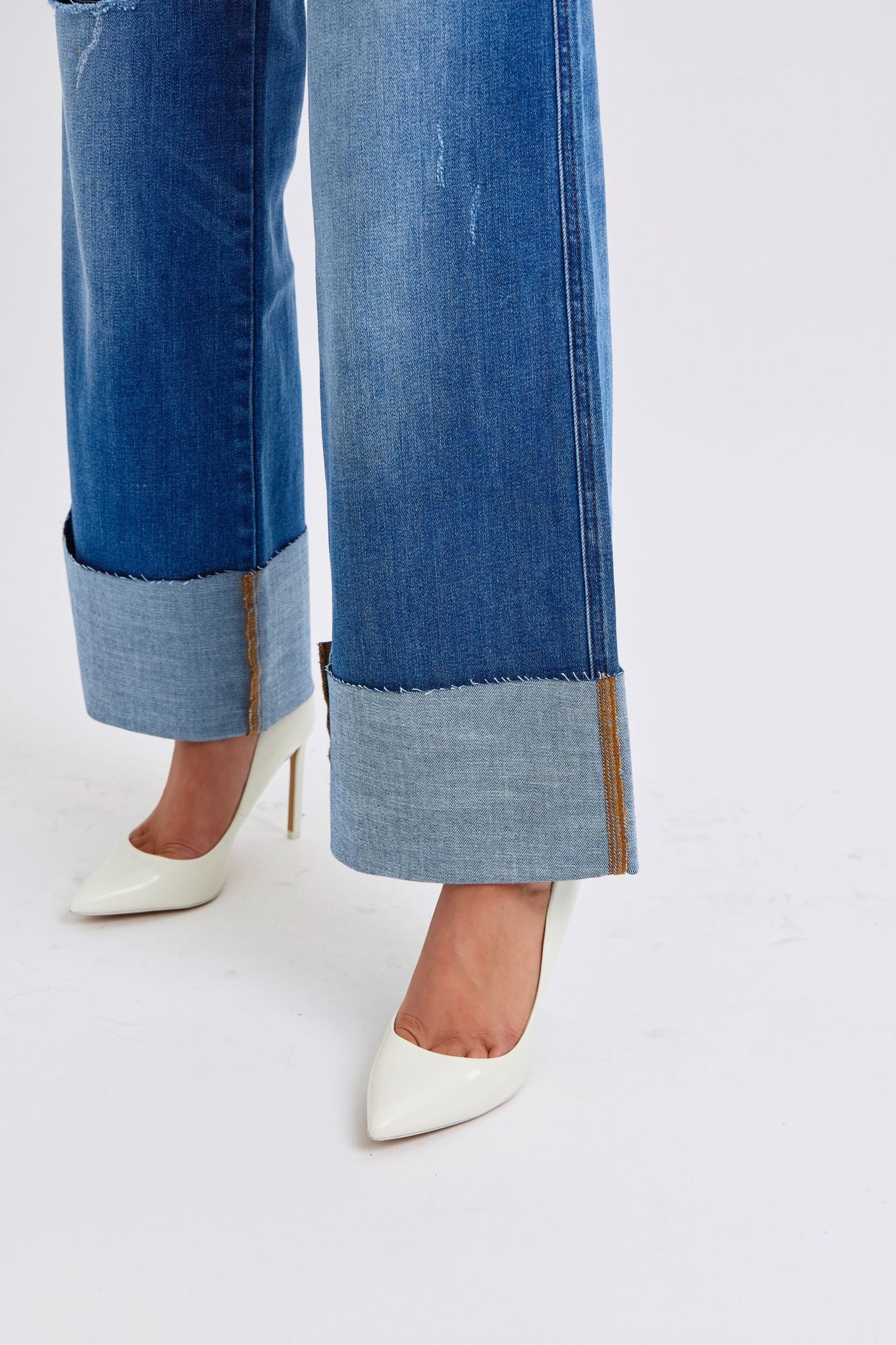 Judy Blue Full Size Distressed High Waist Wide Leg Jeans with white heels.