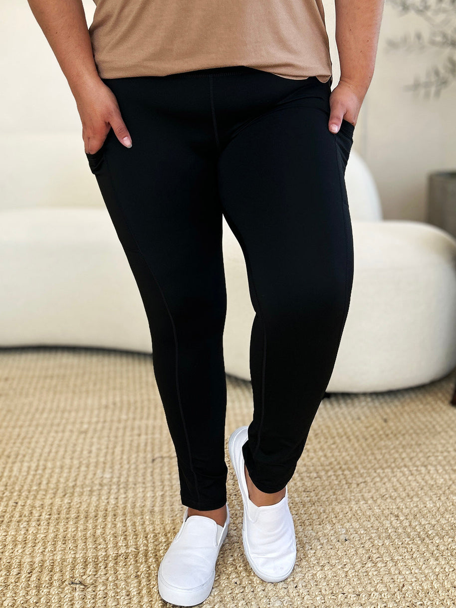 Wide waistband sports leggings in black, featuring a stretchy nylon-spandex blend, perfect for fitness activities.