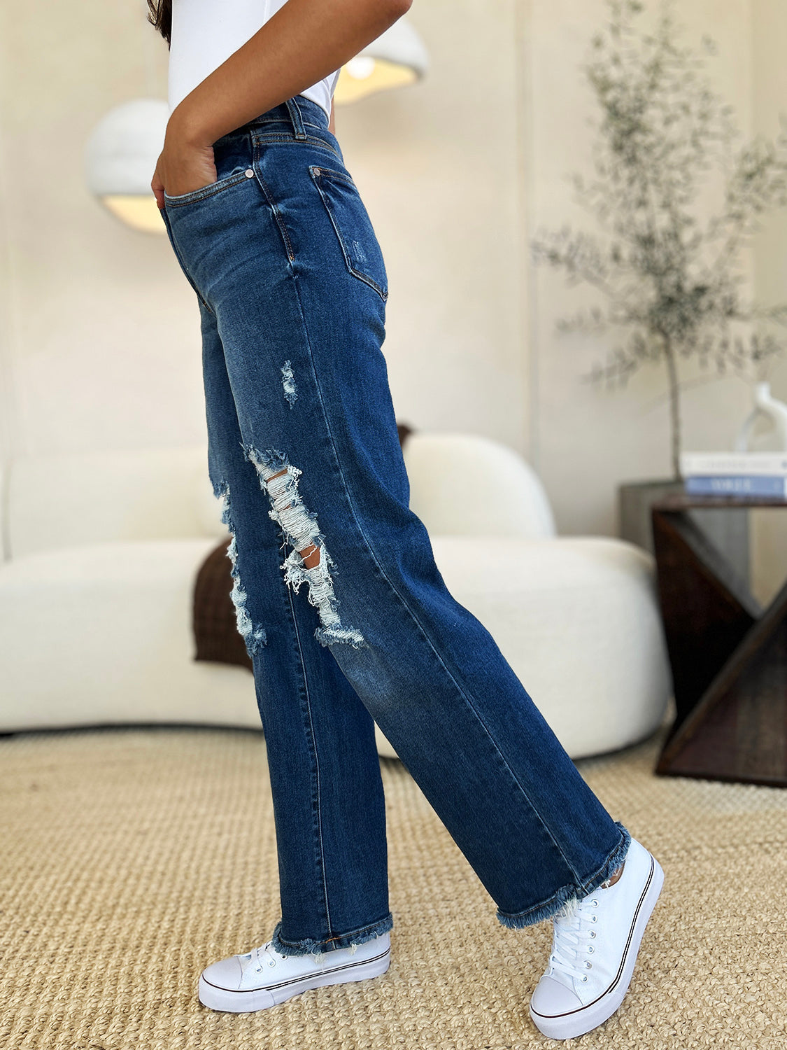 Judy Blue mid rise distressed raw hem jeans with white sneakers in a casual setting.