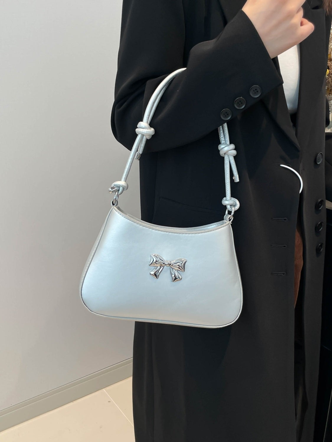 Small Bow PU Leather Knotted Strap Handbag in white carried by a woman.