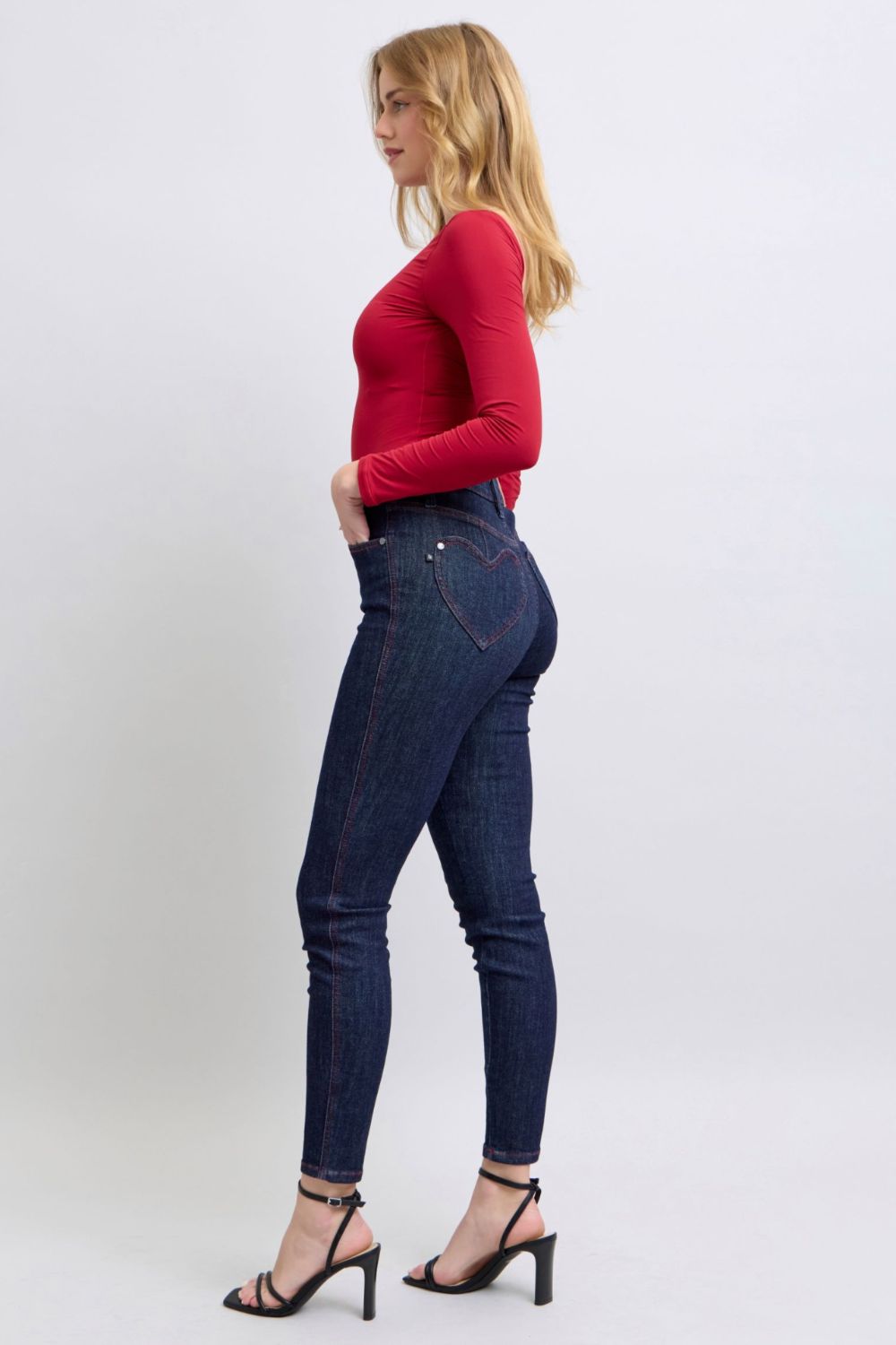 Judy Blue skinny jeans with heart-shaped back pockets, worn with a red top.