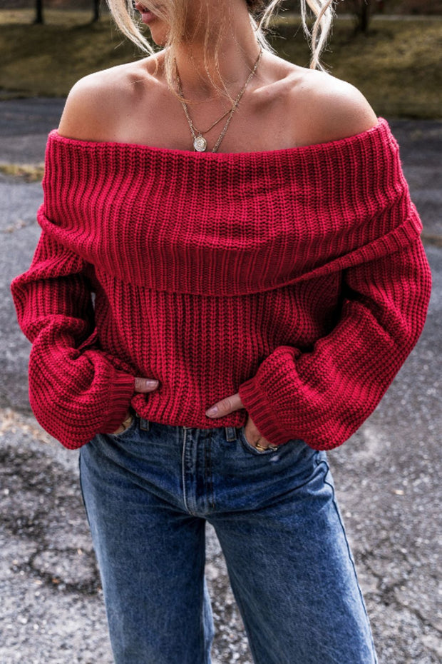 Red off-shoulder long sleeve sweater with a ribbed texture, paired with jeans.