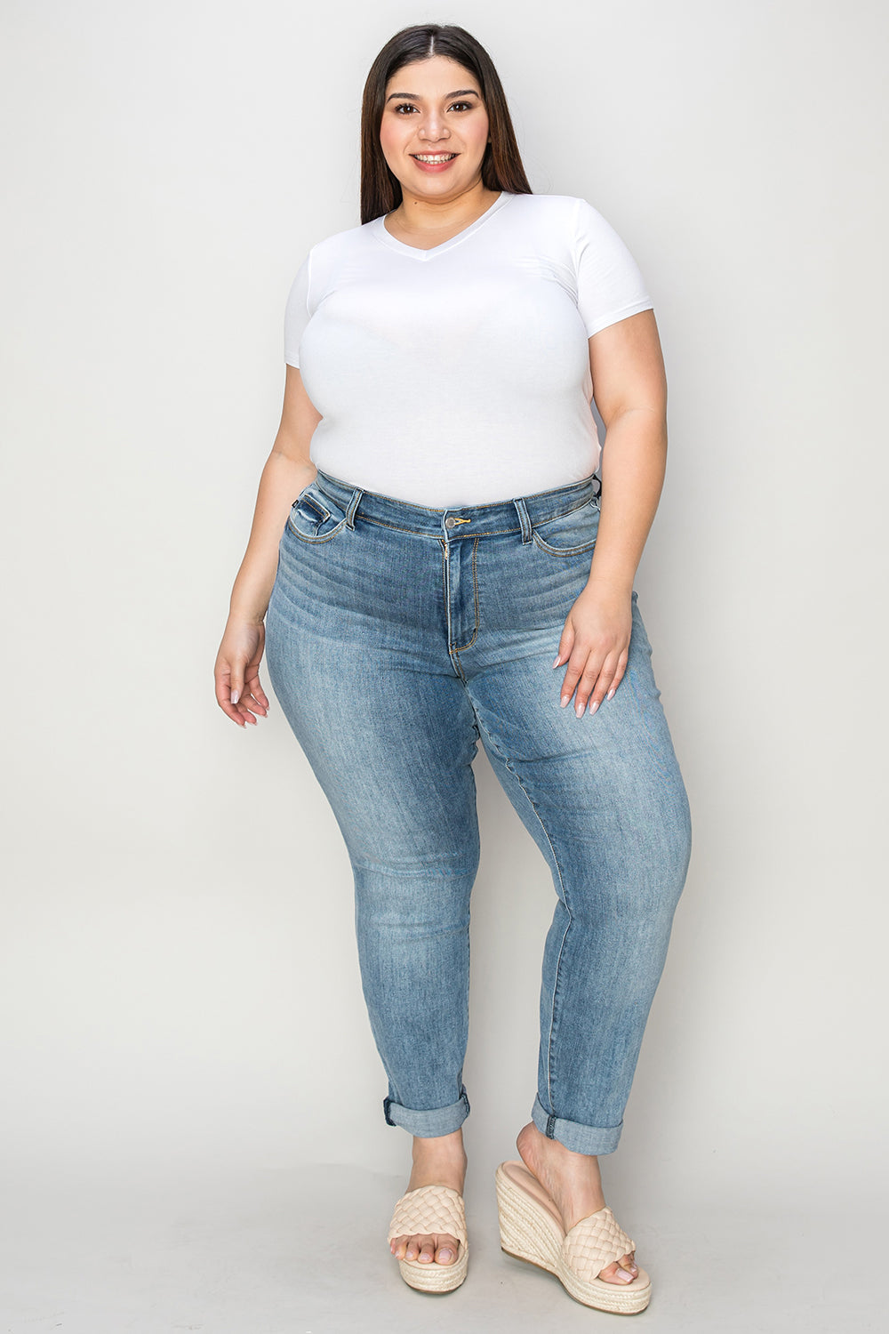 Plus-size woman wearing Judy Blue Full Size Cuffed Hem Slim Jeans with a white top and sandals.