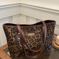 Leopard Polyester Tote Bag with large size and brown handles on table.