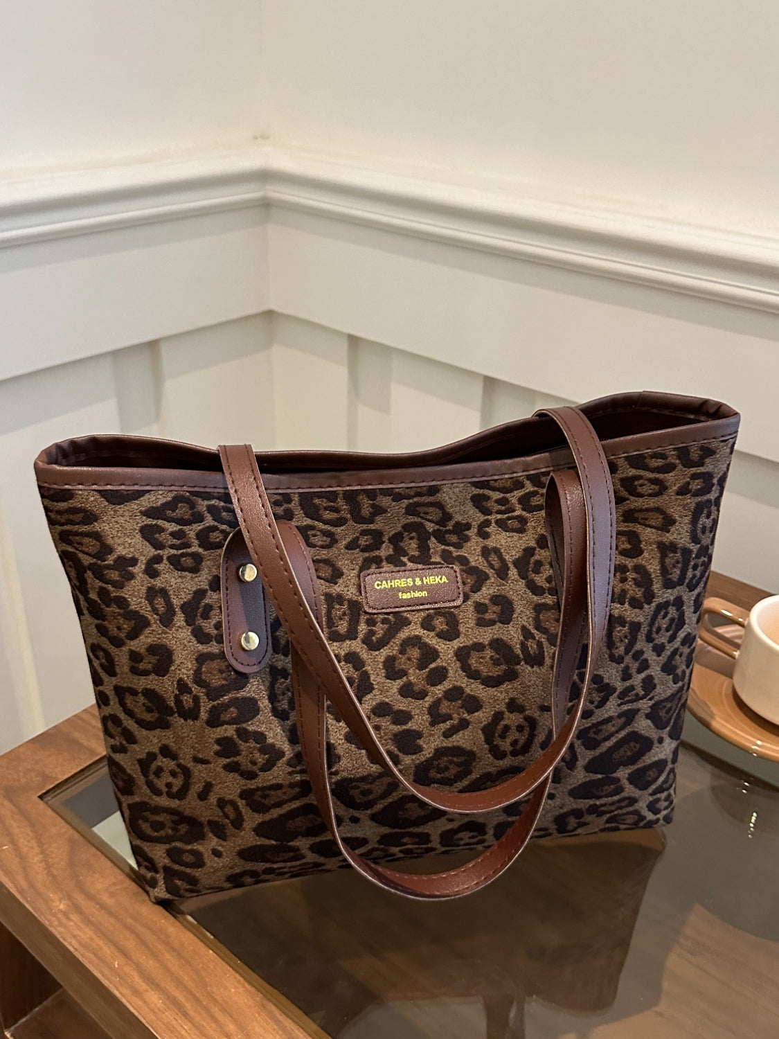 Leopard Polyester Tote Bag with large size and brown handles on table.