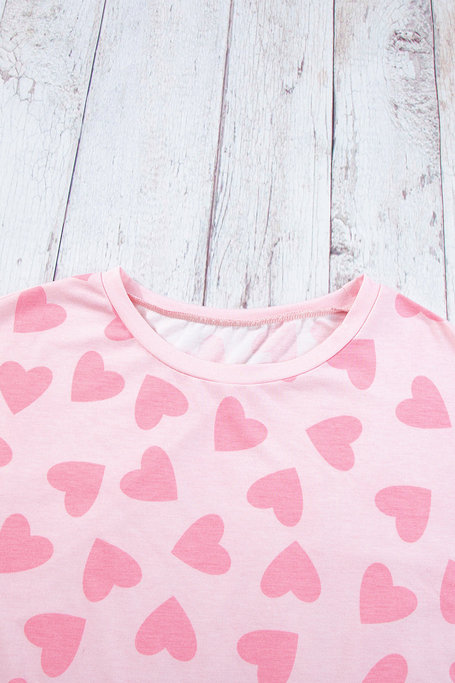 Heart Print Long Sleeve Top in pink with heart pattern on wood background.