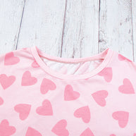 Heart Print Long Sleeve Top in pink with heart pattern on wood background.