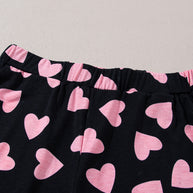 Heart print long sleeve top and shorts lounge set, pink hearts on black fabric.