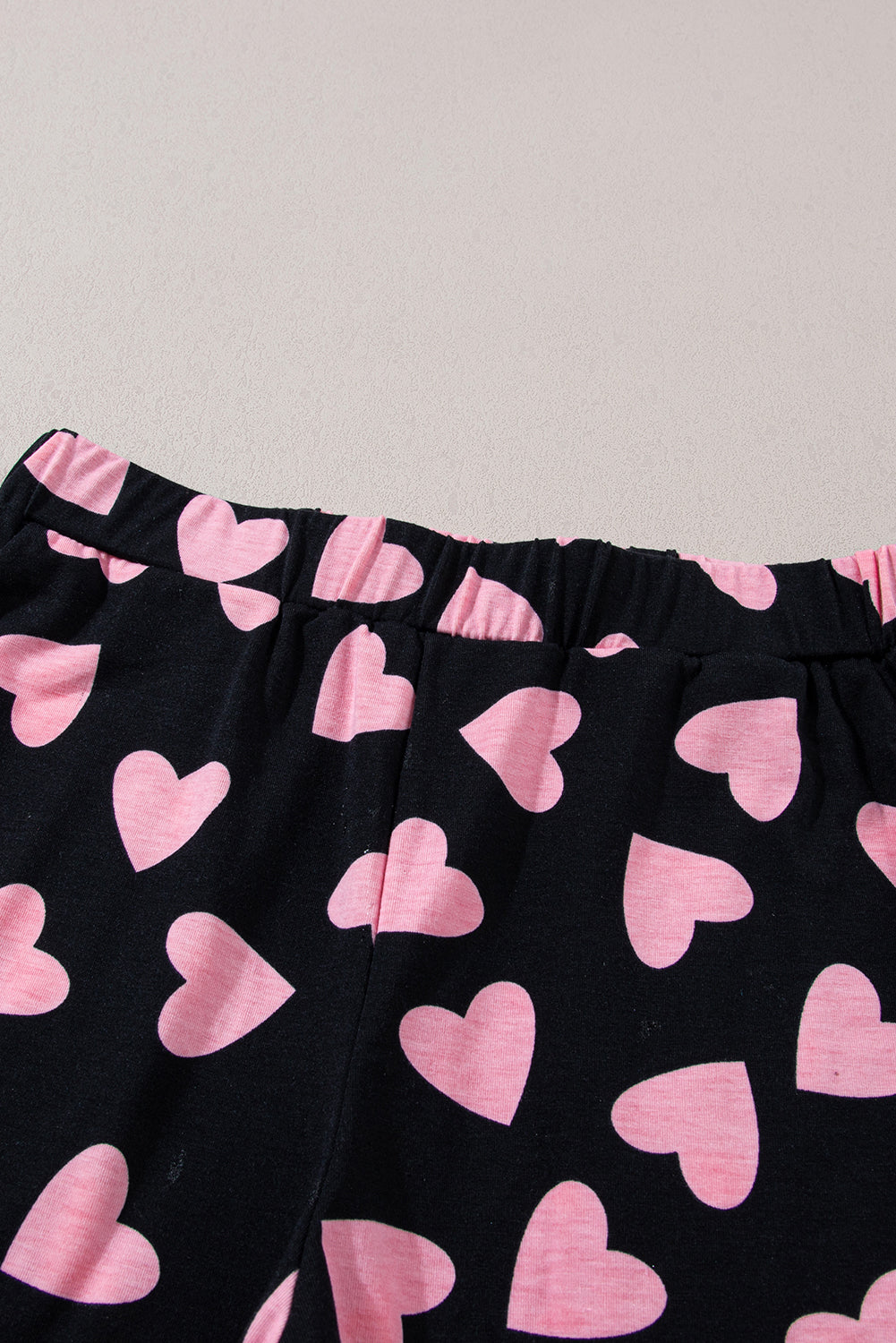 Heart print long sleeve top and shorts lounge set, pink hearts on black fabric.