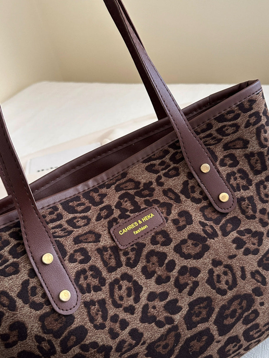 Leopard polyester tote bag with brown leather straps.