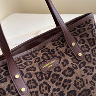 Leopard polyester tote bag with brown leather straps.