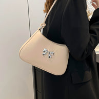 Small bow PU leather handbag with knotted strap, light beige color.