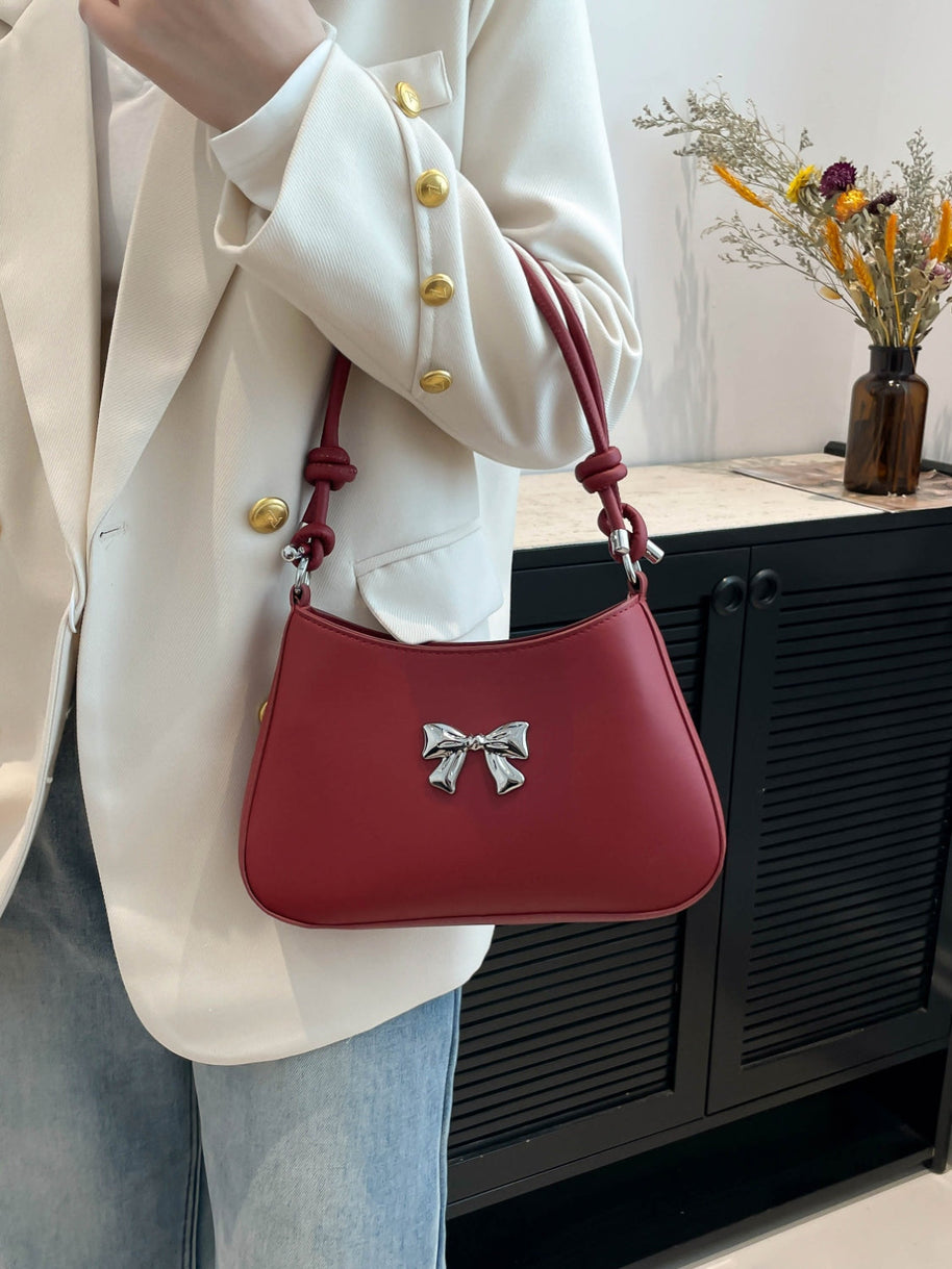 Small red bow PU leather handbag with knotted strap design.