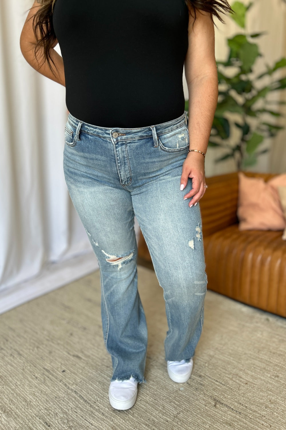 Judy Blue Full Size Medium Rise Tummy Control Destroy Flare Jeans on model, showcasing distressed detailing and flare design.