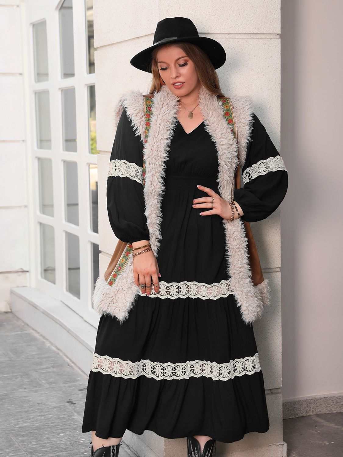 Plus size lace detail V-neck long sleeve midi dress in black, worn by model with hat and fur vest.