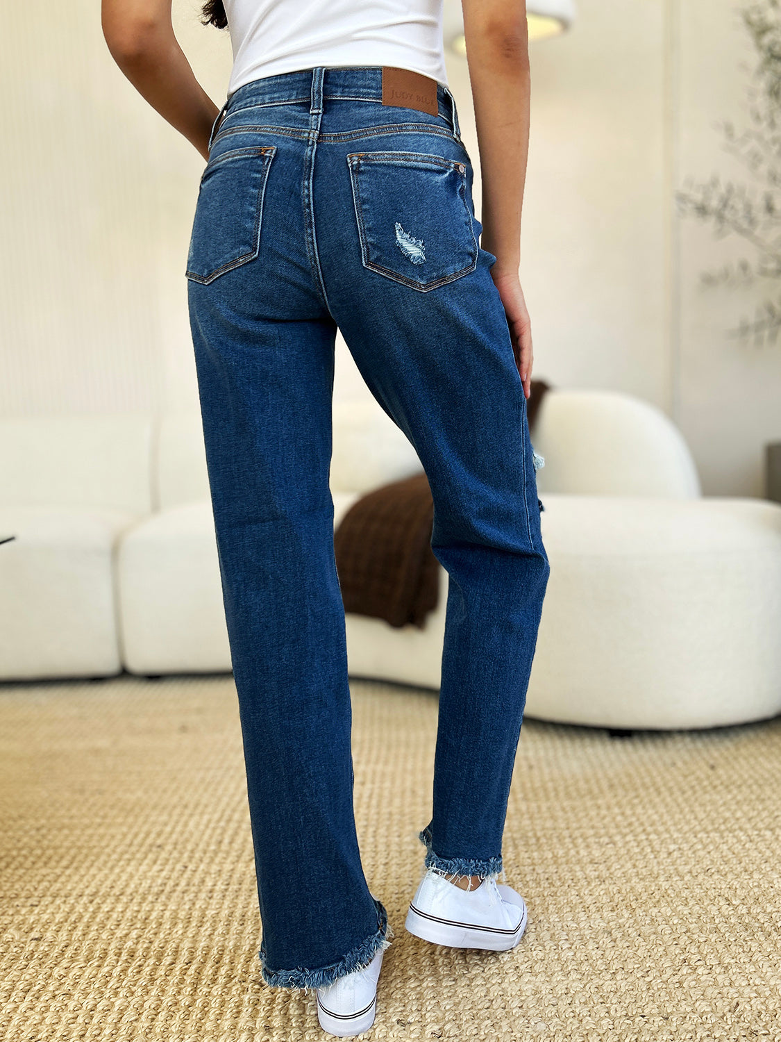 Judy Blue mid rise distressed raw hem jeans, back view, casual style.