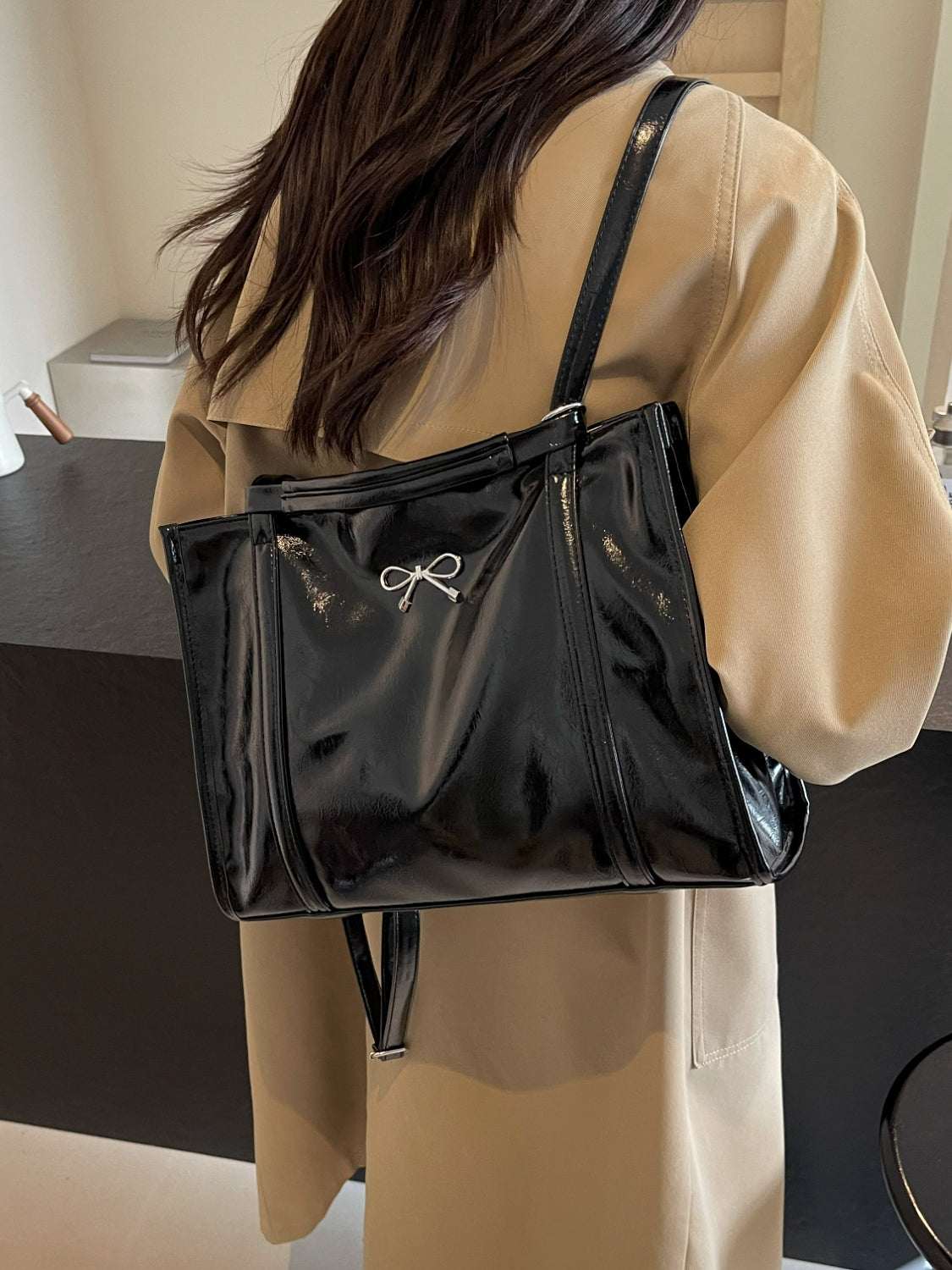 Black PU leather bow shoulder bag with spacious design.