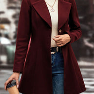 Women's collared neck button up long sleeve coat in burgundy, worn over a white turtleneck.