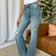 Judy Blue medium rise tummy control flare jeans with distressed detailing and raw hem.