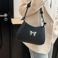 Small bow PU leather handbag with knotted strap in black.