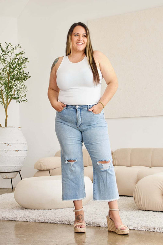 RFM full size tummy control high waist raw hem distressed jeans in light wash worn by a smiling woman.