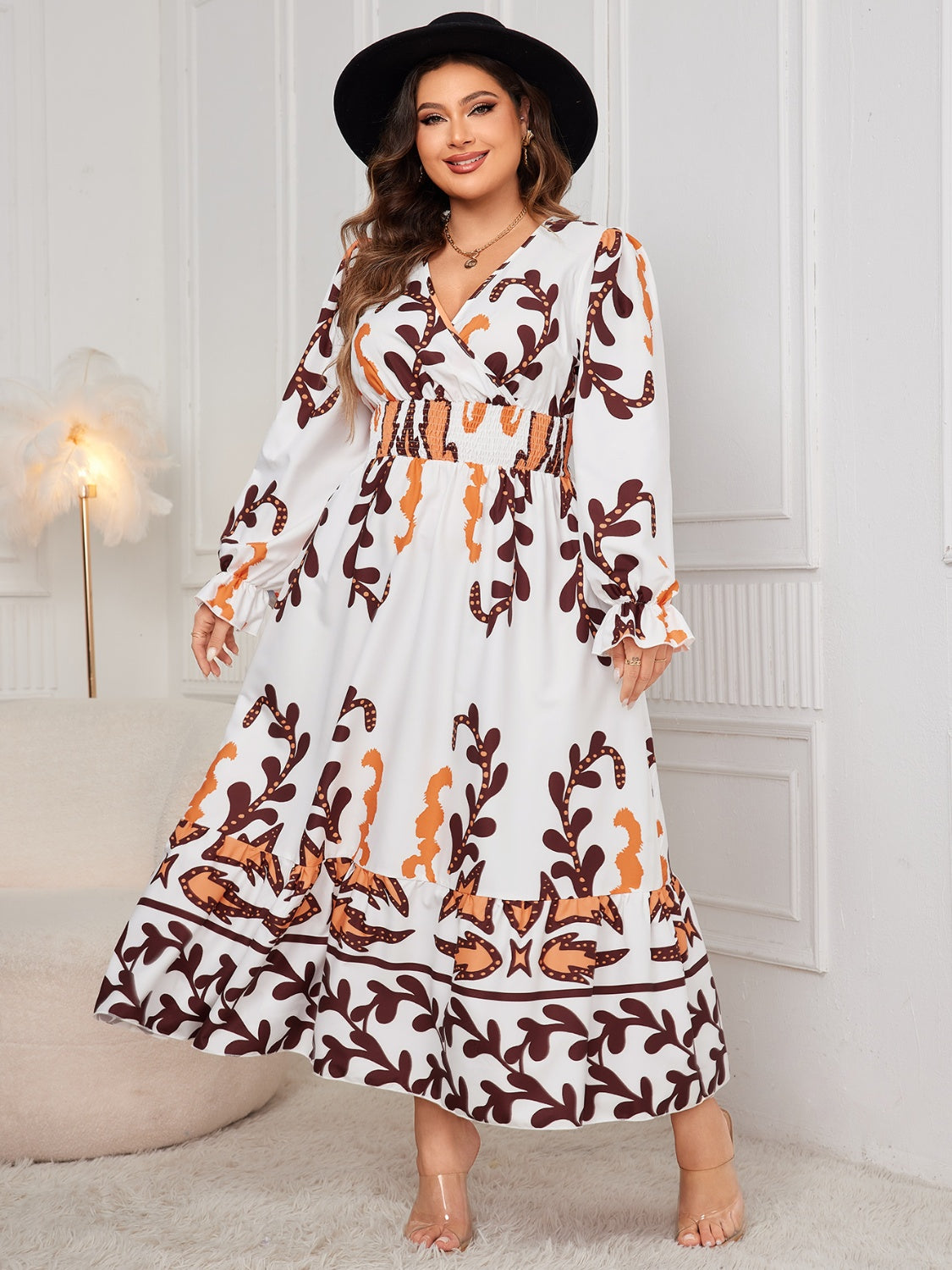 Plus size printed surplice flounce sleeve dress in white with orange and brown pattern.