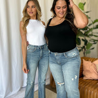 Judy Blue medium rise tummy control flare jeans with distressed detailing, worn by two models in a casual setting.