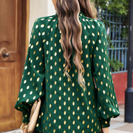 Cutout printed mock neck long sleeve blouse in green with gold pattern, back view.