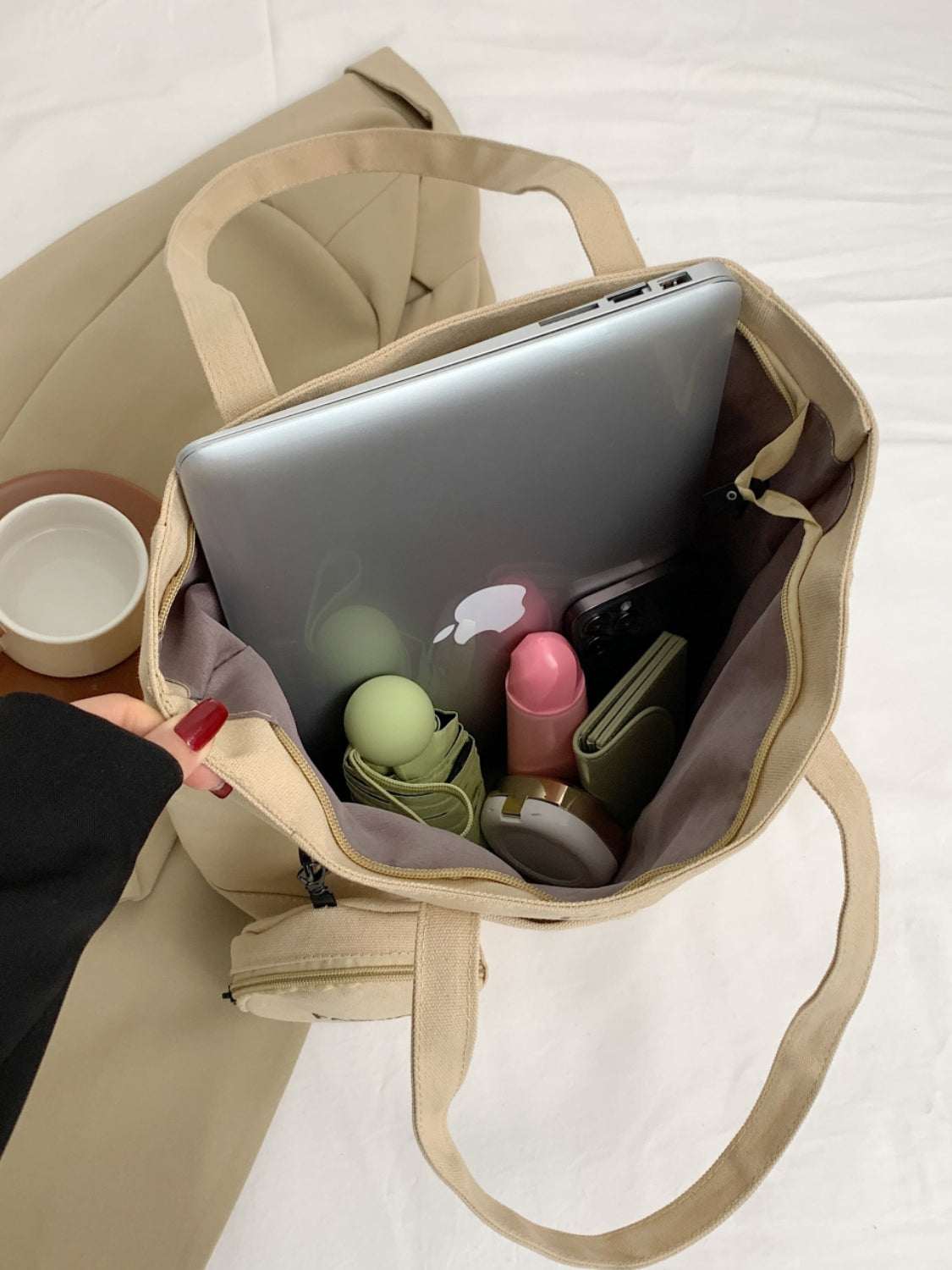 Canvas tote bag with pouch holding laptop and essentials.