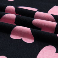 Close-up of pink heart print on a black fabric from a long sleeve top.