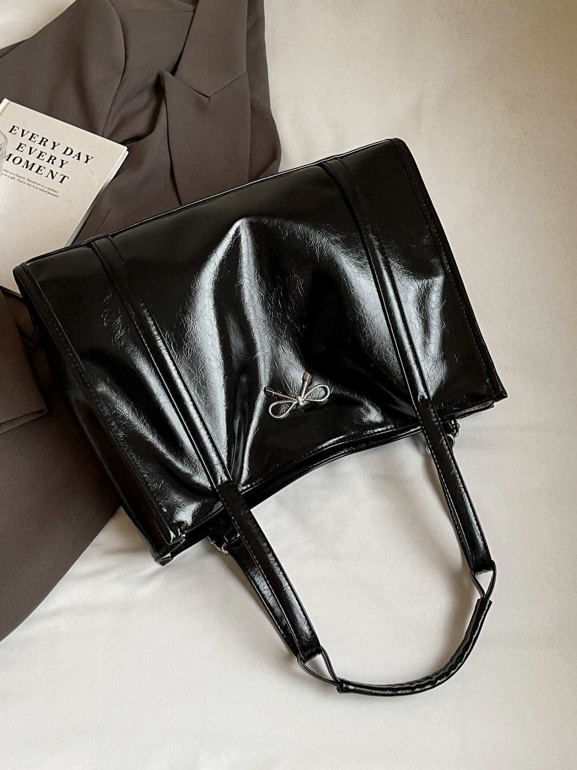 PU leather bow shoulder bag in black with spacious design for daily essentials.