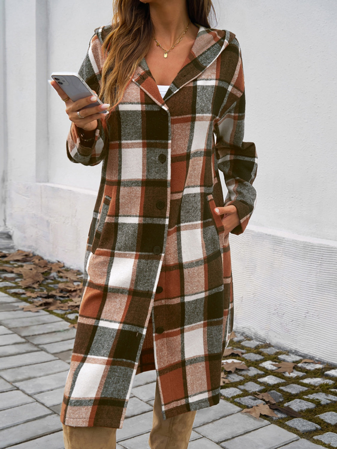 Plaid long sleeve hooded coat with buttoned front and pockets.