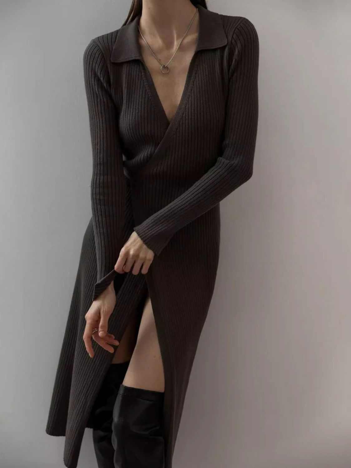 Tied collared neck long sleeve sweater dress with slit and moderate stretch in dark color.