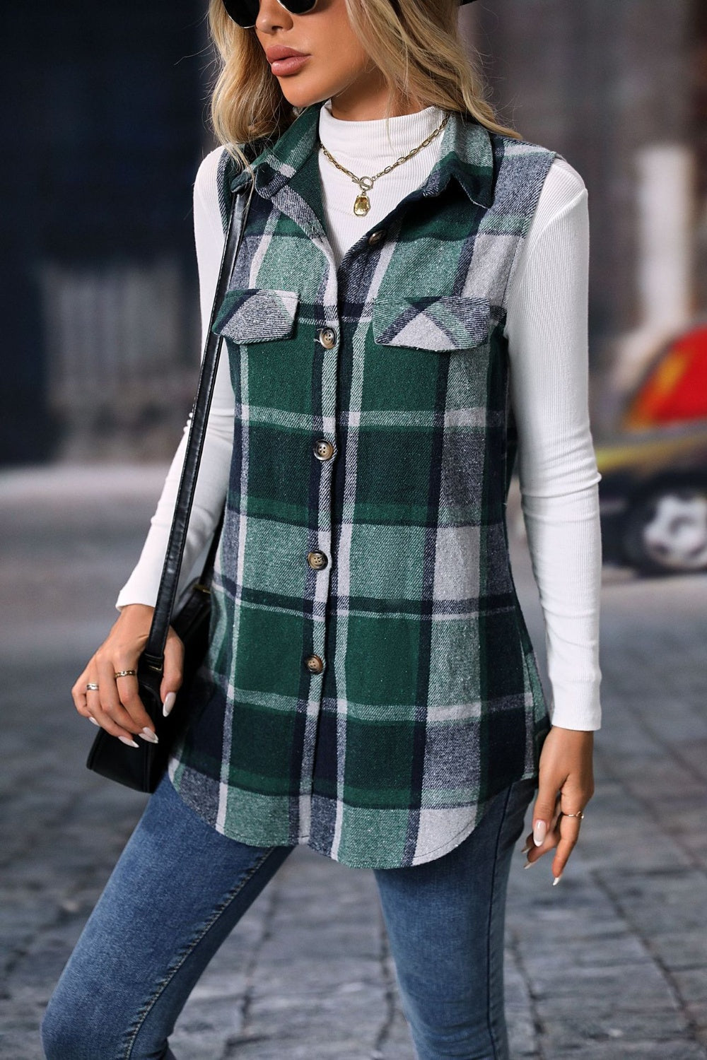 Plaid button up vest coat in green and navy tones with front pockets and a collared neckline.