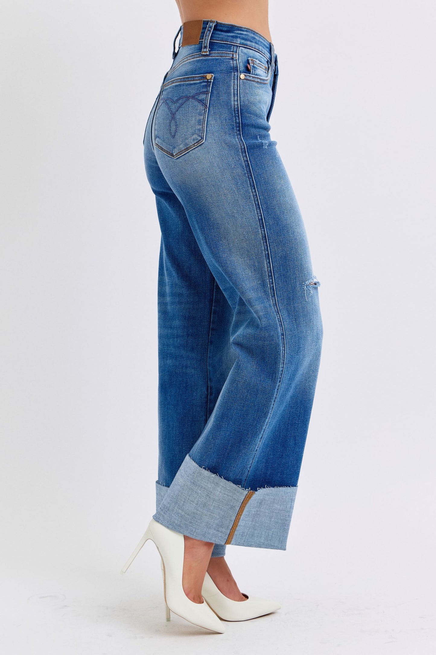 Judy Blue Full Size Distressed High Waist Wide Leg Jeans with white heels.