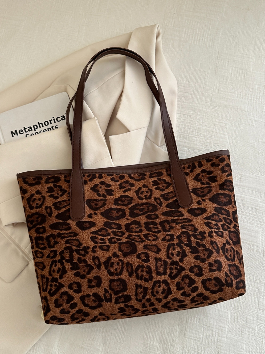 Leopard polyester tote bag with large size and brown handles.