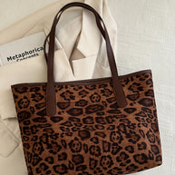 Leopard polyester tote bag with large size and brown handles.