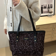 Leopard print polyester tote bag in large size with black handles.