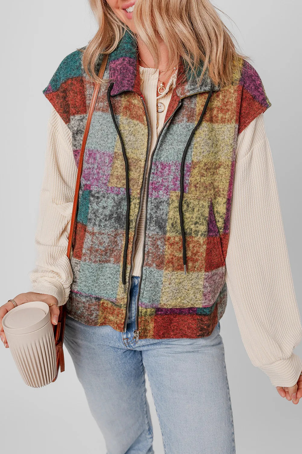 Plaid zip-up collared neck vest coat with drawstring, 100% polyester, worn by model holding a cup.