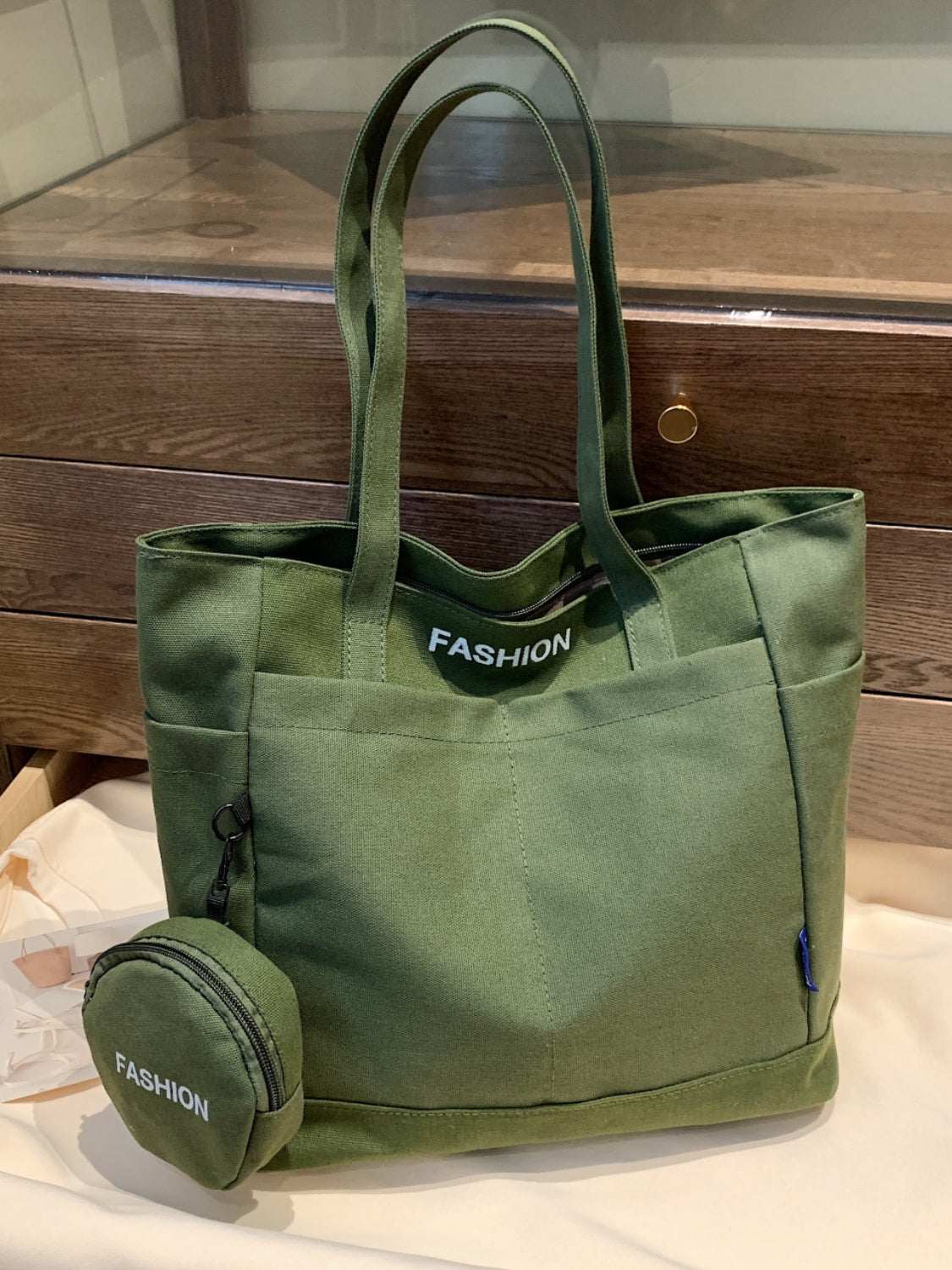 Green canvas tote bag with matching pouch, durable and spacious for everyday use.