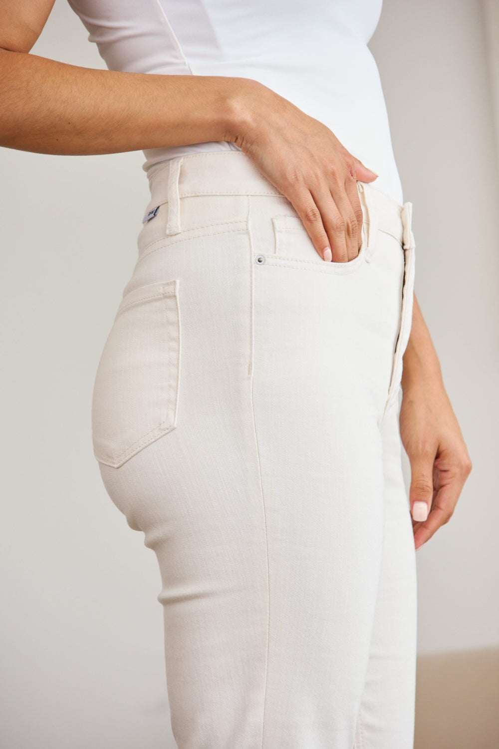 RFM Mini Mia Full Size Tummy Control High Waist Raw Hem Jeans in cream, showcasing side pocket with raw hem detail.