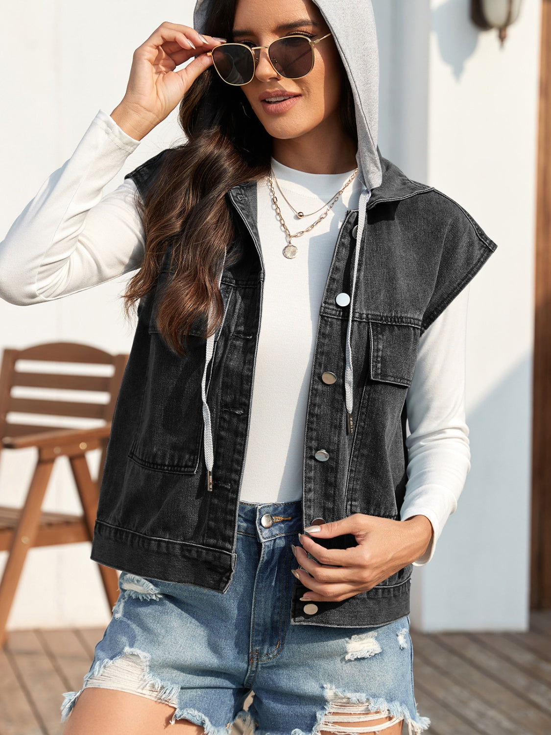 Sleeveless denim jacket with drawstring and button-up design.