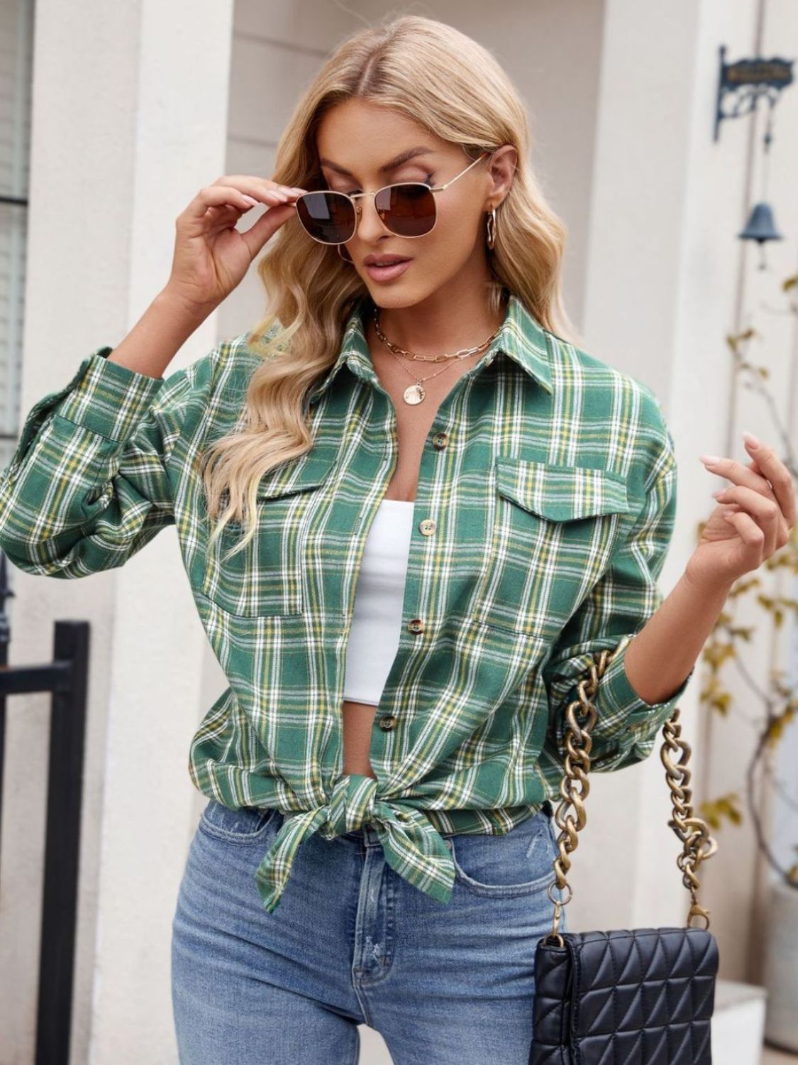 Plaid button-up shirt with long sleeves, buttoned pockets, and a tied front style.