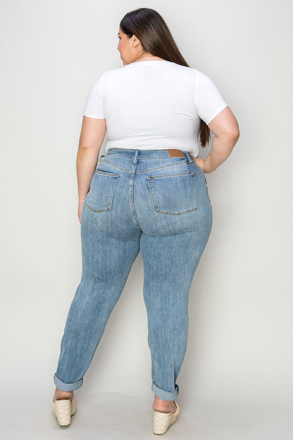 Judy Blue full size cuffed hem slim jeans on model, rear view.